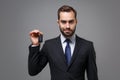 Handsome young business man in classic black suit shirt tie posing isolated on grey wall background, studio portrait Royalty Free Stock Photo