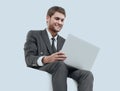 Handsome young business man sitting on a white modern chair Royalty Free Stock Photo