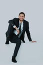 Handsome young business man sitting on a white modern chair. Royalty Free Stock Photo