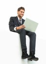 Handsome young business man sitting on a white modern chair Royalty Free Stock Photo
