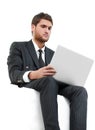 Handsome young business man sitting on a white modern chair Royalty Free Stock Photo