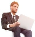 Handsome young business man sitting on a white modern chair Royalty Free Stock Photo