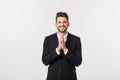 Handsome young business man standing praying, isolated over white background. Concept of idea, ask question, think up Royalty Free Stock Photo