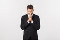 Handsome young business man standing praying, isolated over white background. Concept of idea, ask question, think up Royalty Free Stock Photo