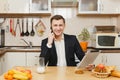 Handsome caucasian young man, sitting at table. Healthy lifestyle. Cooking at home. Prepare food. Royalty Free Stock Photo