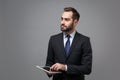 Handsome young business man in suit shirt tie posing isolated on grey background. Achievement career wealth business