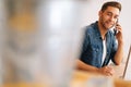 Handsome young business man talking on mobile phone sitting at desk with laptop at home office, lookingat camera. Royalty Free Stock Photo