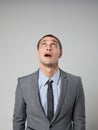 Handsome young business man thinking on gray background Royalty Free Stock Photo