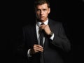 Handsome young businessman adjusting his tie. young man in suit Royalty Free Stock Photo