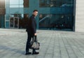 Handsome young businessman with a beard and in a business suit standing on the street Royalty Free Stock Photo