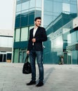 Handsome young businessman with a beard and in a business suit standing on the street Royalty Free Stock Photo