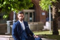 Handsome young businessman, bearded and in suit, posing calmly gazing into infinity. Concept beauty, fashion, success, achiever,