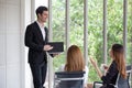 handsome young businessman or boss,Manager,speaker giving presentation with laptop to employees in the office or meeting room