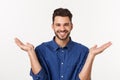 Handsome young businessman in classic suit smiling, looking at camera keeping palm up on white background. Business man Royalty Free Stock Photo