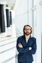 Handsome young businessman with folded arms in the office. Cheerful self confident man with crossed hands portrait. Business Royalty Free Stock Photo