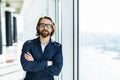 Handsome young businessman with folded arms in the office. Cheerful self confident man with crossed hands portrait. Business Royalty Free Stock Photo