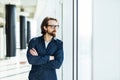 Handsome young businessman with folded arms in the office. Cheerful self confident man with crossed hands portrait. Business Royalty Free Stock Photo