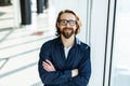 Handsome young businessman with folded arms in the office. Cheerful self confident man with crossed hands portrait. Business Royalty Free Stock Photo