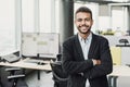 Handsome young businessman with folded arms in the office. Cheerful self confident men with crossed hands portrait. Business succe Royalty Free Stock Photo