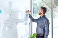 Businessman in the office writing notes on whiteboard.