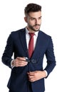 Handsome young businessman holding his glasses and adjusting his jacket Royalty Free Stock Photo