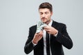 Handsome young businessman holding and smelling money