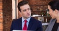 Handsome young businessman looking at businesswoman during meeting at office cafeteria Royalty Free Stock Photo