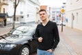 Handsome young businessman man near a black car on the street. Royalty Free Stock Photo