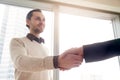 Handsome young businessman shaking female hand, deal or business