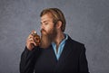 Handsome young businessman smelling perfume isolated grey background