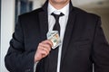 handsome young businessman in a stylish jacket from a suit with a large sum of dollars. Royalty Free Stock Photo