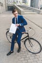 handsome young businessman in stylish suit with newspaper leaning Royalty Free Stock Photo