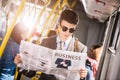handsome young businessman in sunglasses reading newspaper in city Royalty Free Stock Photo