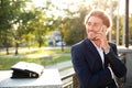 Handsome young businessman talking on mobile phone in park Royalty Free Stock Photo