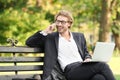 Handsome young businessman talking by mobile phone in park Royalty Free Stock Photo