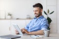 Handsome Young Businessman Using Digital Tablet At Workplace In Office, Browsing App