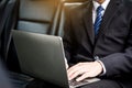 Handsome Young businessman using laptop and sitting in back seat Royalty Free Stock Photo