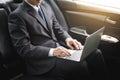 Handsome Young businessman using laptop and sitting in back seat Royalty Free Stock Photo