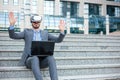 Handsome young businessman using virtual reality simulator and making hand gestures, working in front of an office building Royalty Free Stock Photo
