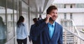 Handsome young businessman walking with mobile phone in front of office building Royalty Free Stock Photo