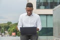 Handsome young businessman working with laptop outdoors at business building Royalty Free Stock Photo