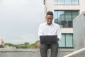 Handsome young businessman working with laptop outdoors at business building Royalty Free Stock Photo