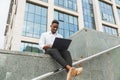 Handsome young businessman working with laptop outdoors at business building Royalty Free Stock Photo