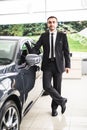 Handsome young classic car salesman standing at the dealership Royalty Free Stock Photo