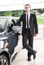 Handsome young classic car salesman standing at the dealership Royalty Free Stock Photo