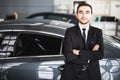 Handsome young classic car salesman standing at the dealership Royalty Free Stock Photo