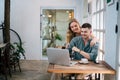 Handsome young couple using laptop together while sitting in chair at home. The concept of couples sharing one idea together Royalty Free Stock Photo