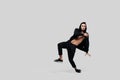 Handsome young dancer of street dancing dressed in black pants, a sweatshirt on a naked torso and a hood dances on a Royalty Free Stock Photo