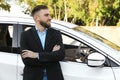 Handsome young driver near modern car on city street Royalty Free Stock Photo