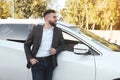 Handsome young driver near modern car on city street Royalty Free Stock Photo